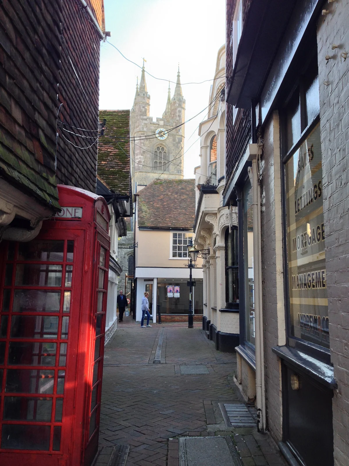 A lane in Ashford town centre with a red telephone box and St Mary’s Church