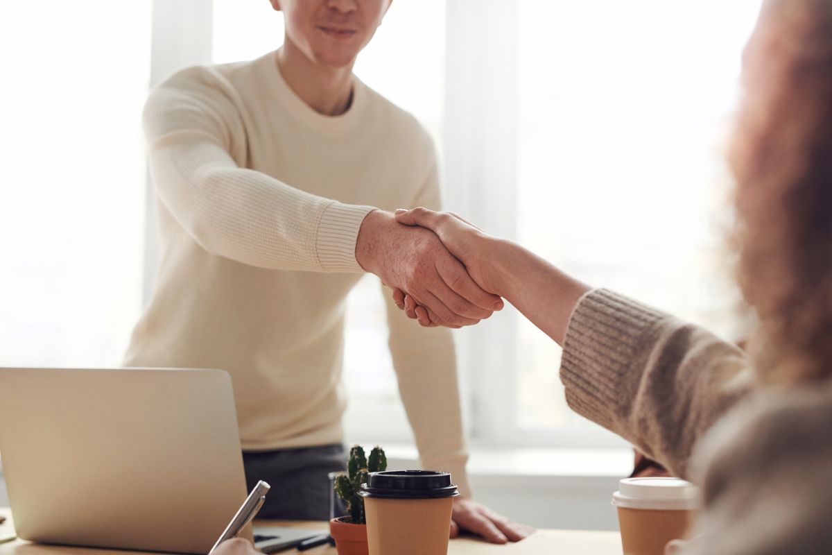 Two people shaking hands during an office meeting