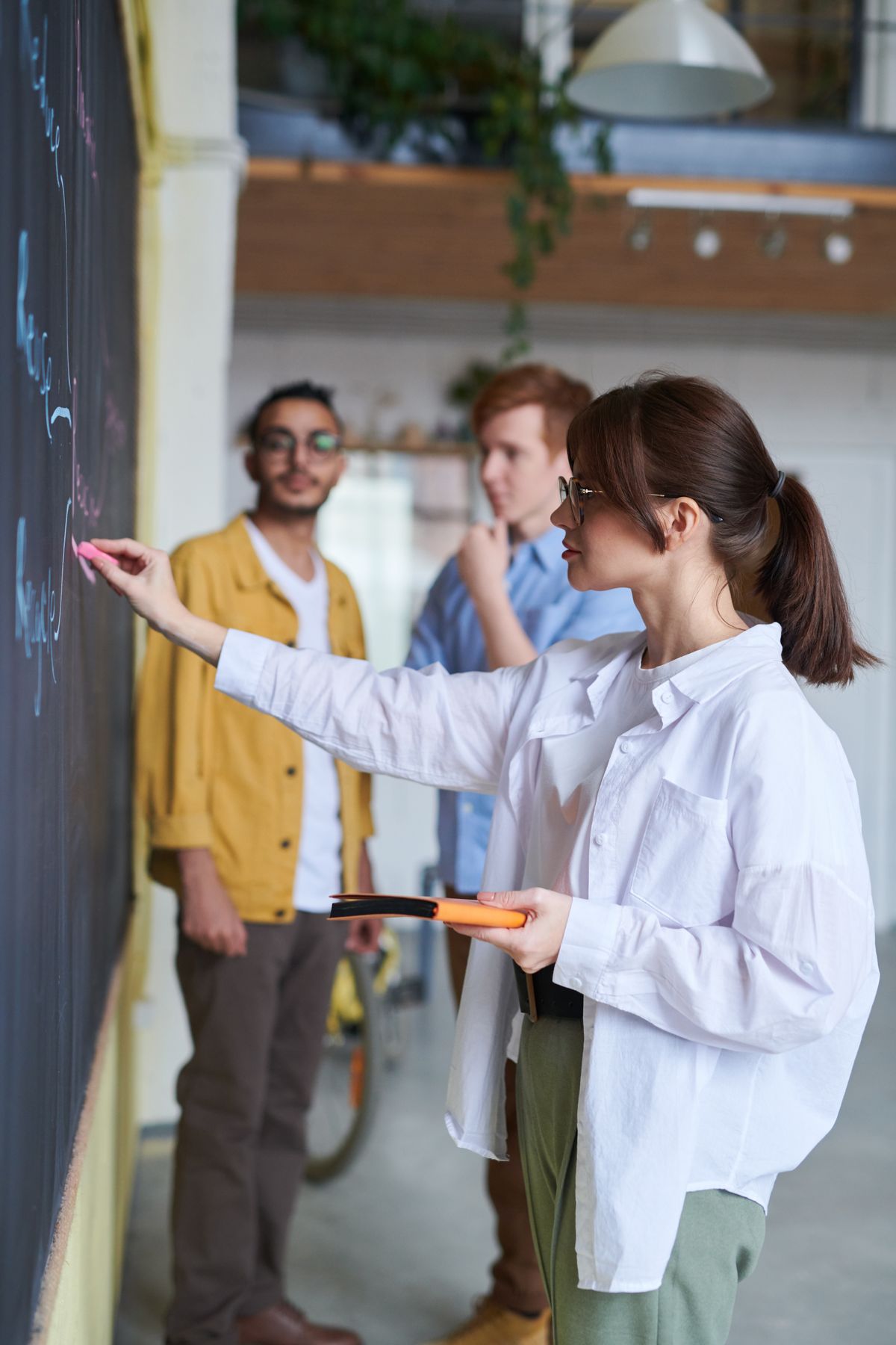 Colleagues discussing ideas at a whiteboard